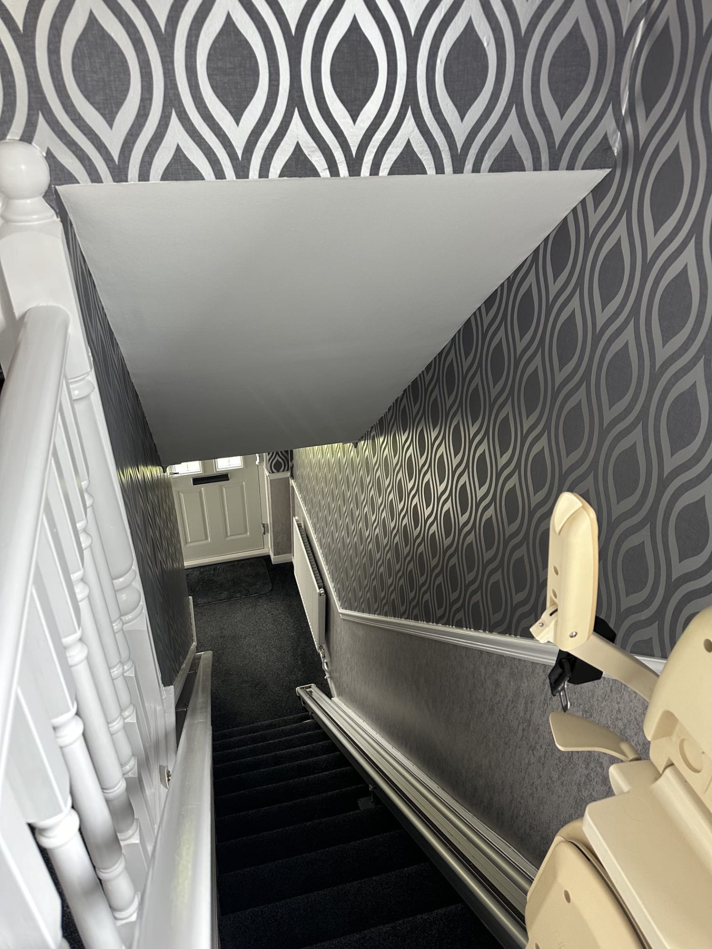 Patterned wallpaper hung on a stairwell landing